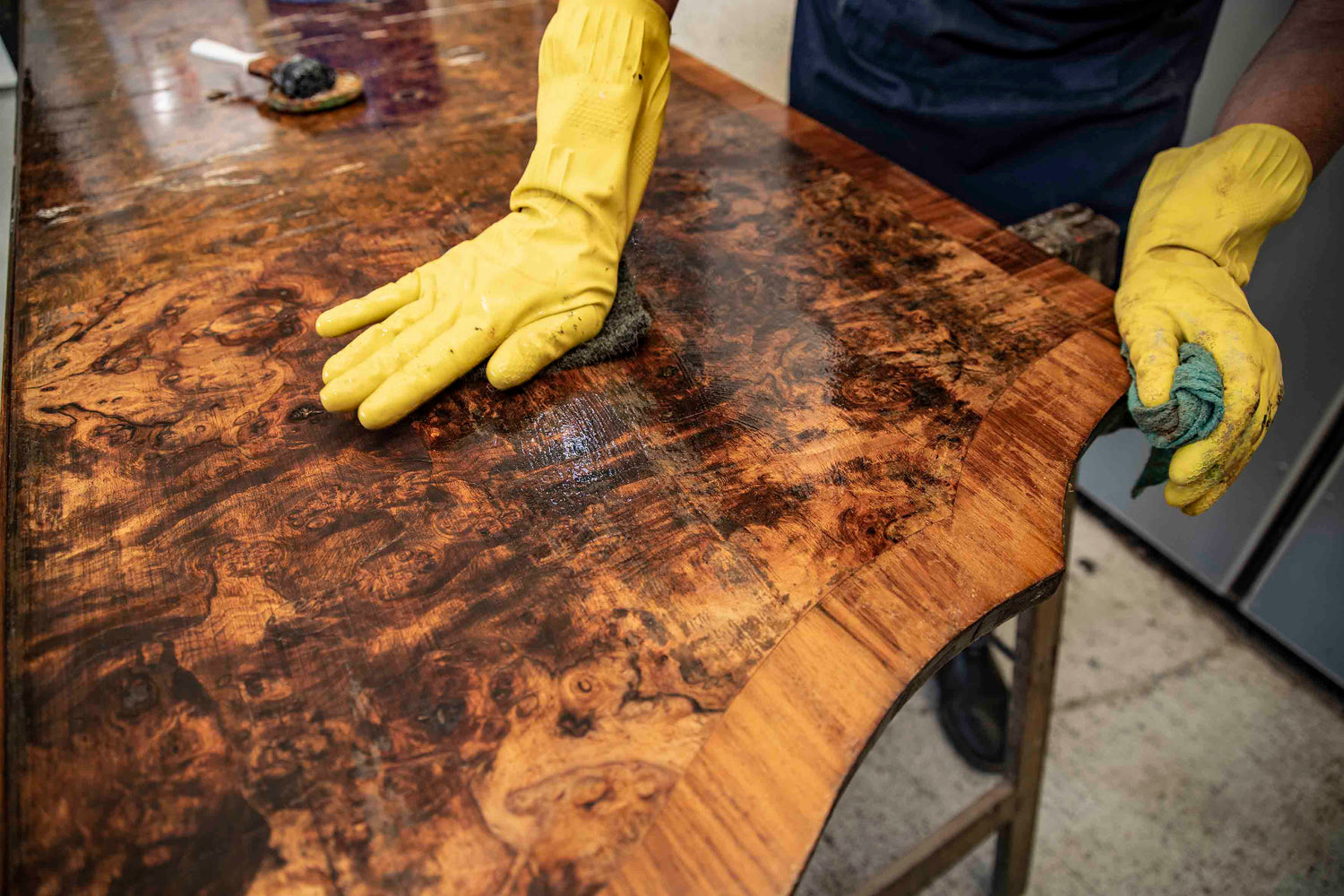 Restaurator glättet eine historische Holzoberfläche von Hand nach dem Entfernen alter Lackschichten und bereitet sie für den neuen Aufbau vor